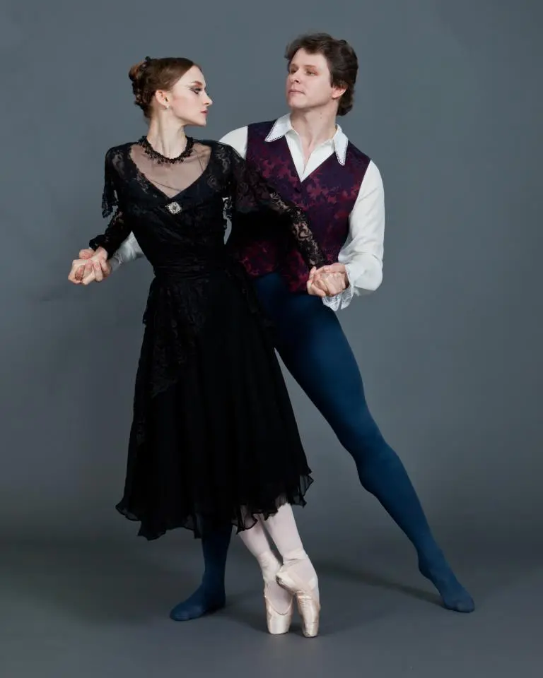 Ballet dancers performing an elegant duet in classic attire.