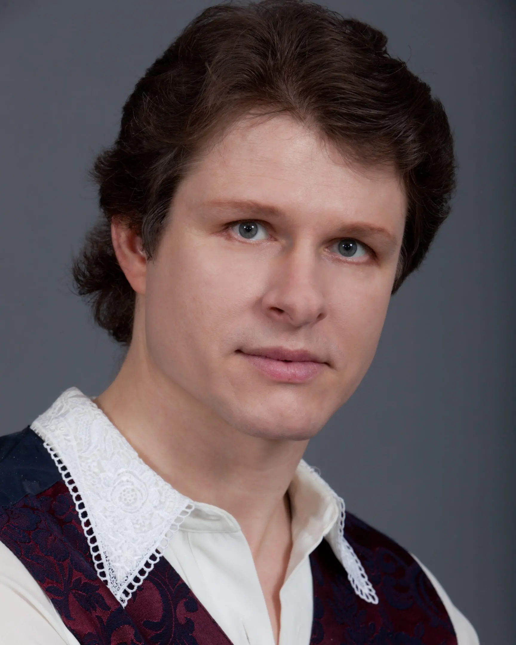 Portrait of a serious young man with light skin and brown hair.