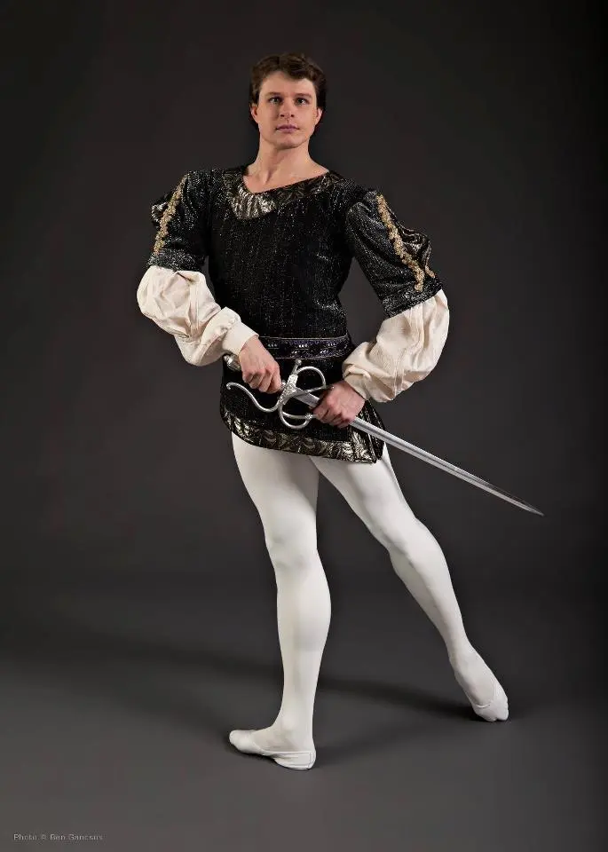 Man in Renaissance costume holding a rapier sword.
